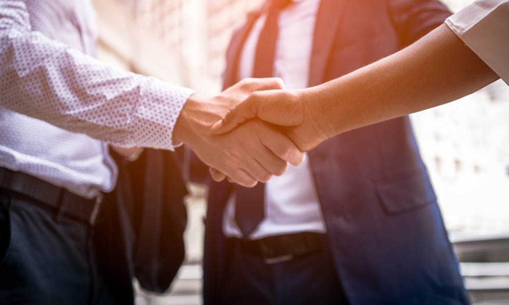 MIS Joins FRP - Close View of Business Professionals Shaking Hands with the Sunrise Behind Them